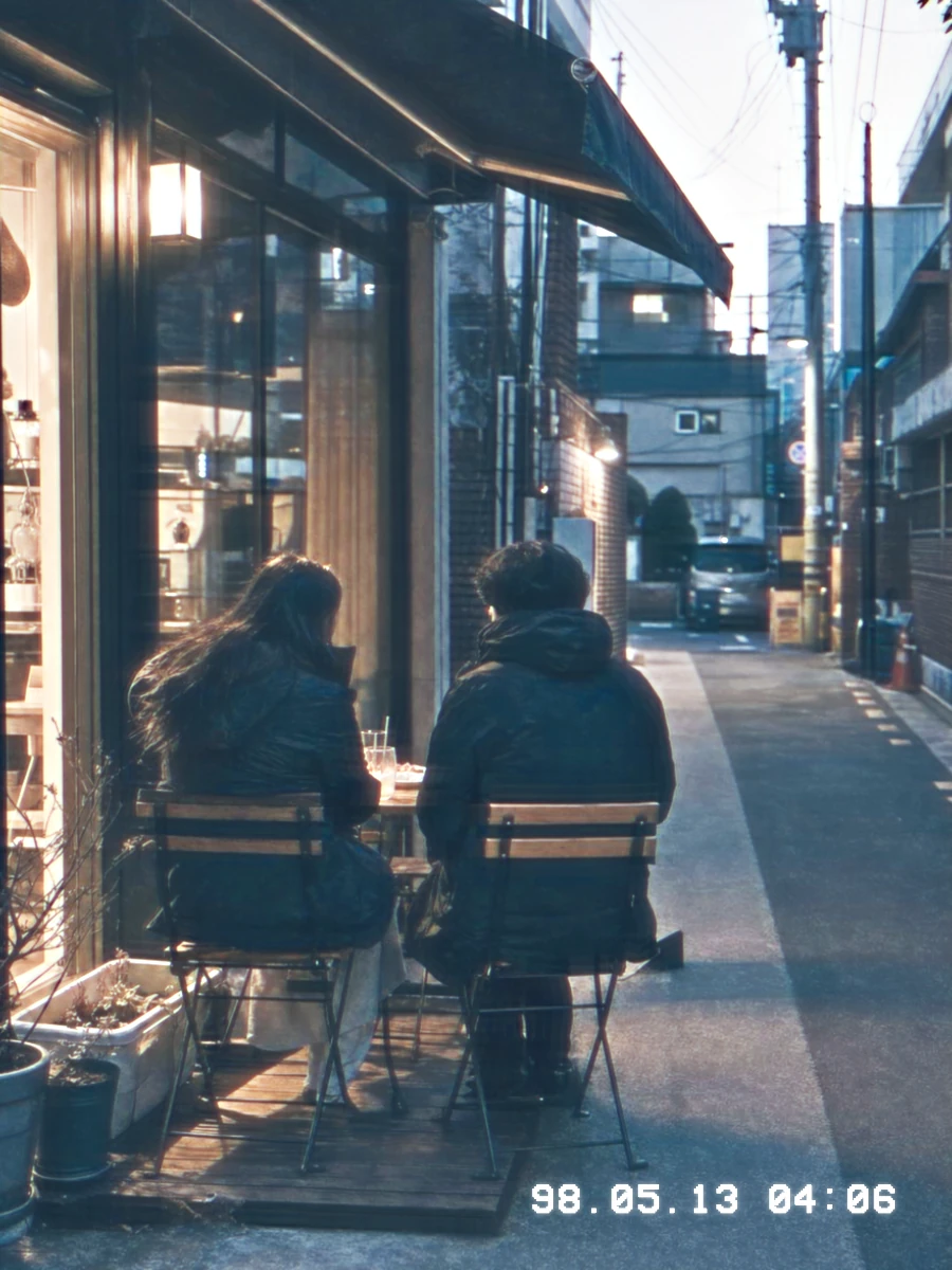 Two people outside a café at dusk, before and after camcorder processing