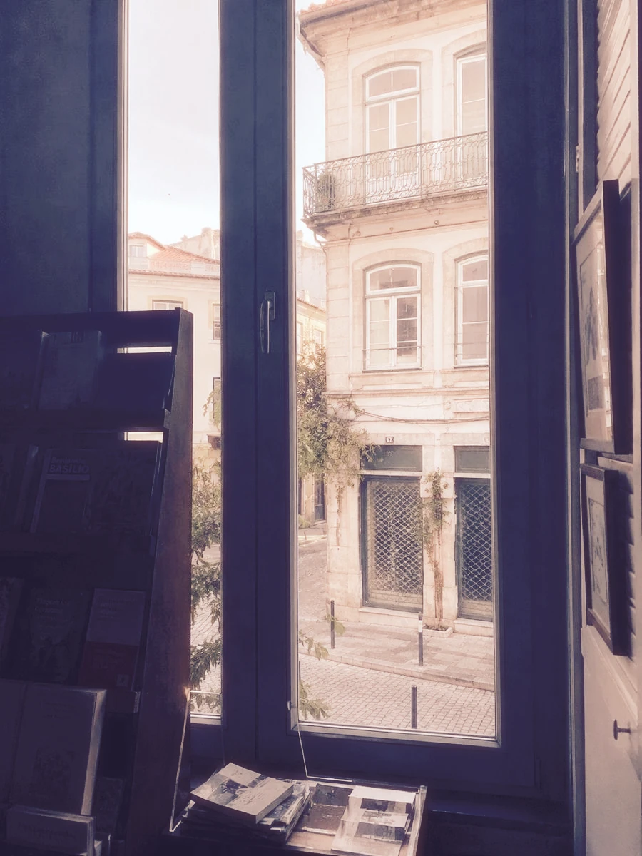 Sunlit stone buildings through an open window, before and after instant-film processing
