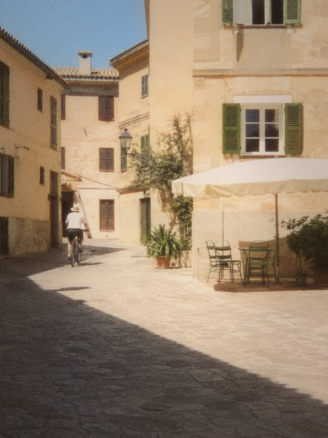 An AI-created sunlit Mediterranean square with grain and weathered Super 8 edges